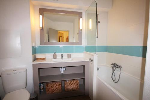 une salle de bain avec un lavabo, des toilettes et un miroir dans l'établissement Horizon, à Collioure