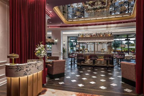 a restaurant with a bar with tables and chairs at Conrad Istanbul Bosphorus in Istanbul
