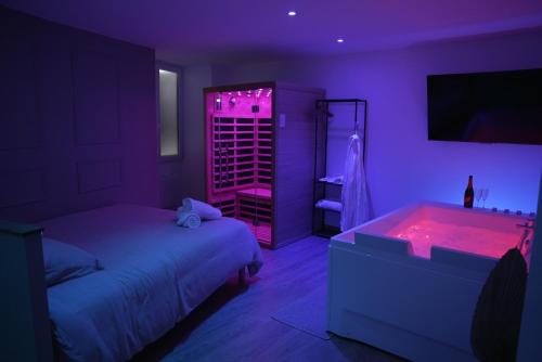 En eller flere senge i et værelse på Suite Détente - Spa & Sauna