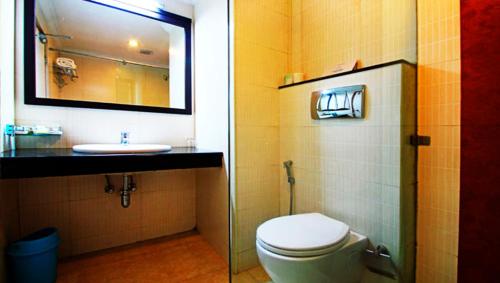 a bathroom with a toilet and a sink and a mirror at Clouds Valley Hotel in Munnar