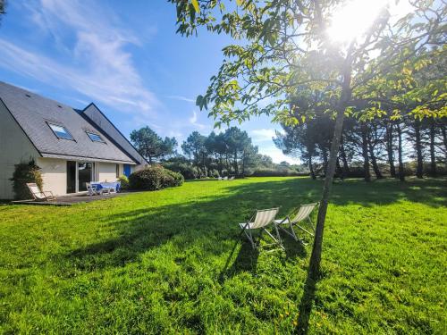 two chairs sitting in the grass next to a house at Holiday Home Le Prado-2 by Interhome in Saint-Philibert
