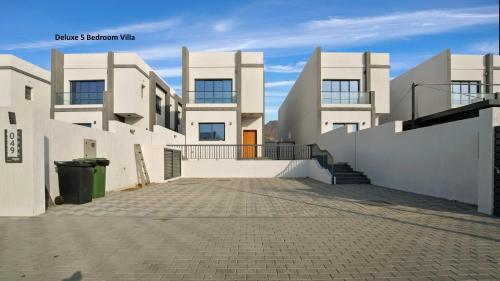 a large white building with a driveway in front of it at Al Dana Paradise Luxury Villas Palm Fujairah Sea View in Fujairah
