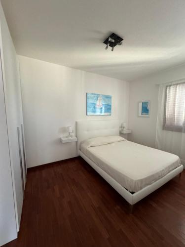 Un dormitorio blanco con una cama grande. en Marco’s Home, en Olbia