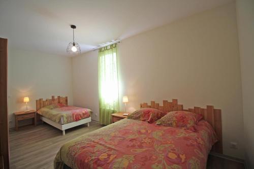 a bedroom with two beds and a window at Gîte Les Champs N°1 in Saint-Mathieu
