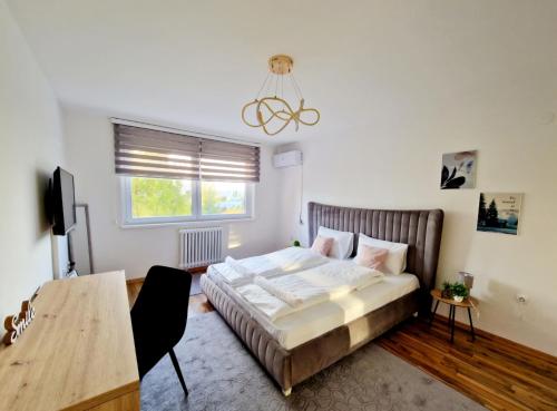 a bedroom with a large bed and a table at Infinity Apartment & Free Wifi & Free Parking in Sarajevo