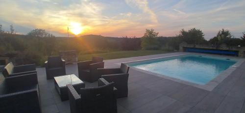 - une piscine avec des chaises et le coucher de soleil en arrière-plan dans l'établissement Les Terrasses du Carlat, Le Logis, Demeure raffinée, situation idéale Dordogne, vues, piscine, à Saint-Cybranet