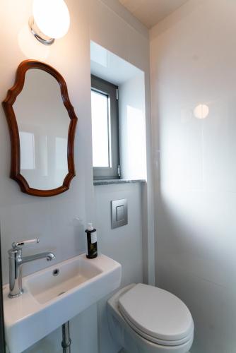 a bathroom with a sink and a toilet and a mirror at LEONIDIONHOUSES - The Lykoskufi Villas in Tiros
