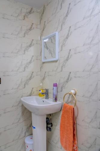 a white bathroom with a sink and a mirror at Dinosaur Anza Surf House in Agadir