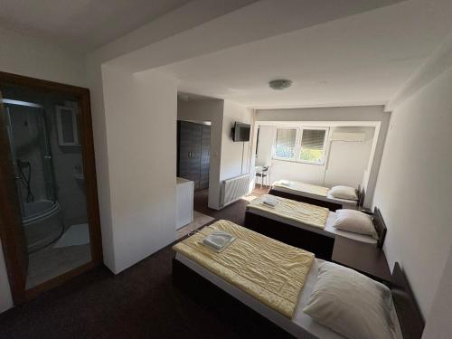 a hotel room with two beds and a bathroom at Hotel Avanti in Zenica