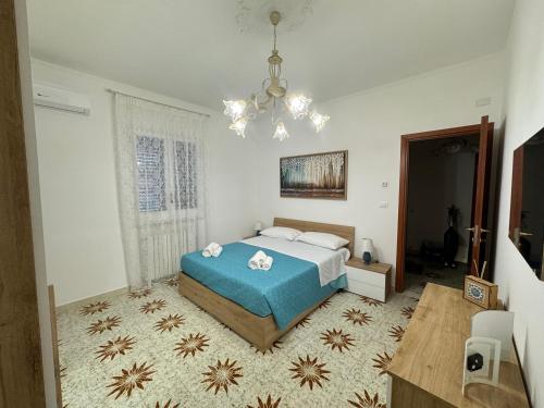 a bedroom with a bed and a chandelier at Villa Lucia appartamento Ischia in Leporano Marina