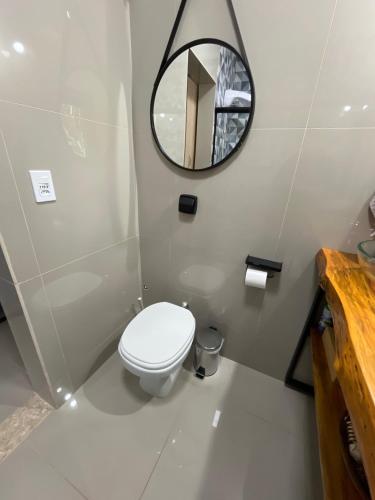 a bathroom with a toilet and a mirror at Cabanas Cantareira - Araucária in Mairiporã