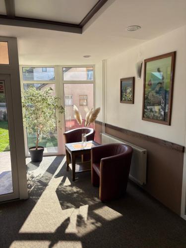 a living room with two chairs and a table at Hotel Avanti in Zenica