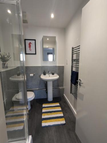 a bathroom with a sink and a toilet at Stunning Modern Coventry City Centre Apartment in Coventry