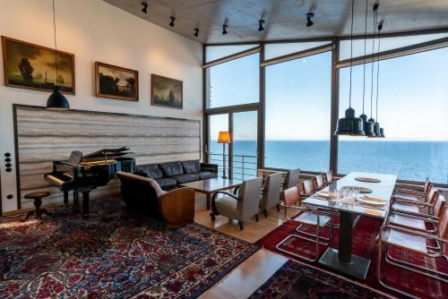 a living room with a table and chairs and the ocean at LEONIDIONHOUSES - The Lykoskufi Villas in Tiros