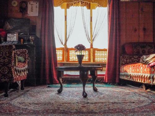 a living room with a table and a couch at Veena Palace Group Of Houseboats in Srinagar