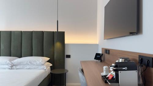 a bedroom with a bed with a green headboard at OMÍ Aparthotel in Caserta