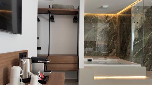 a kitchen with a sink and a glass shower at OMÍ Aparthotel in Caserta