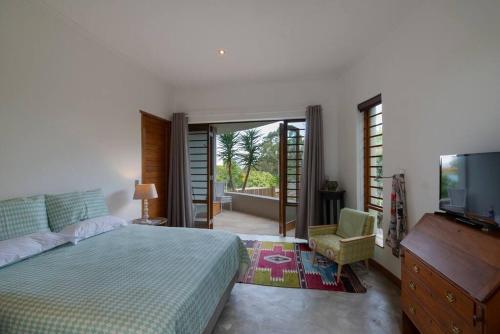 a bedroom with a bed and a flat screen tv at Paradise Hideaway in Knysna