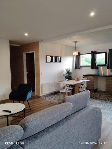 a living room with a couch and a table at Gite de la salamandre in Pléguien