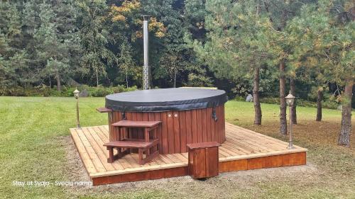 a wooden sauna with a bench on a wooden deck at Stay at Svaja in Plungė