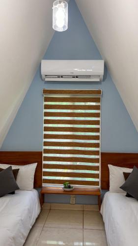 a bedroom with two beds and a window with a heater at VILLAS EL ENCANTO in Jalpan