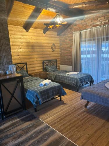 a room with two beds in a log cabin at Hotel Riverside Inn in Martuni