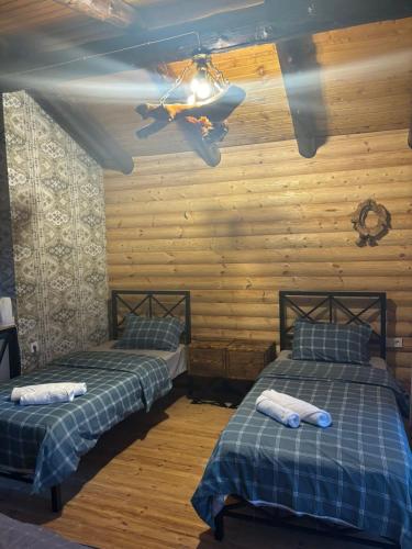 two beds in a room with wooden walls at Hotel Riverside Inn in Martuni