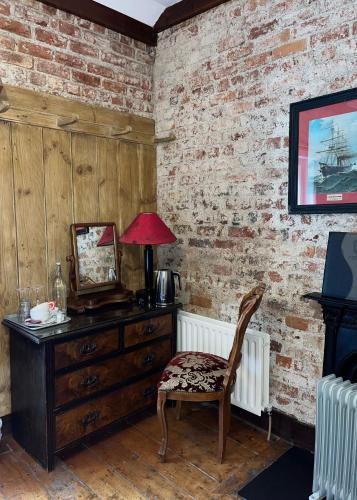 a room with a dresser and a chair and a mirror at Clone House Event Villa in Aughrim