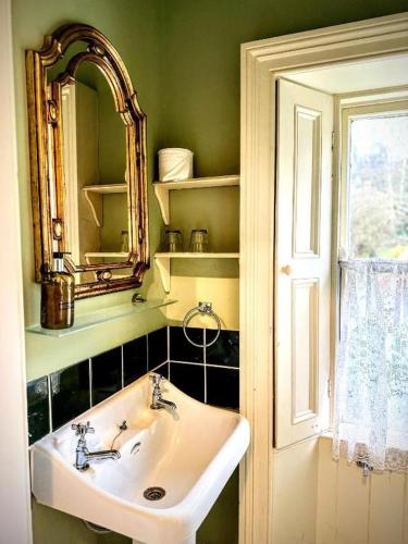 a bathroom with a sink and a mirror and a window at Clone House Event Villa in Aughrim