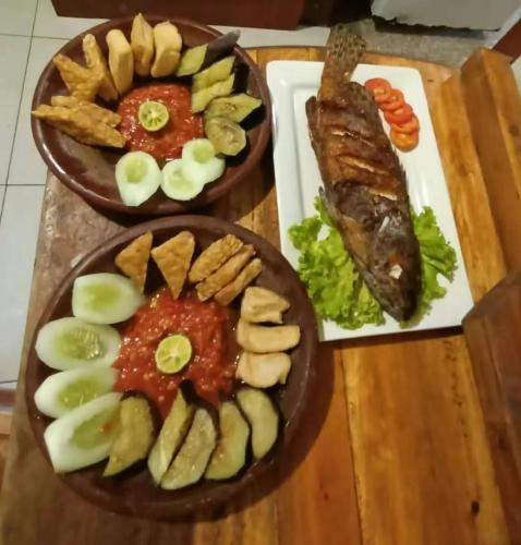 two plates of food on a table with meat and vegetables at Awang Bungalows And Restaurants in Awang