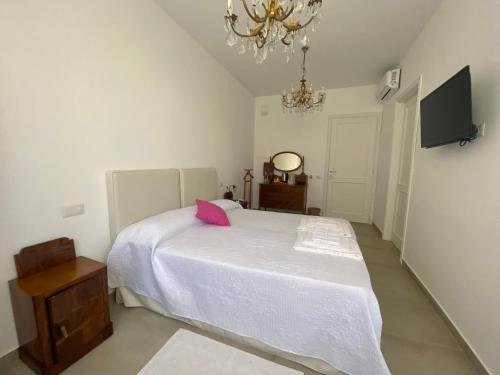 a bedroom with a white bed with a pink pillow at Locanda dei Buoni e Cattivi in Cagliari