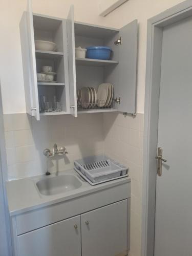 a kitchen with a sink and a white cabinet at Studios Αποστόλης Selianitika in Aígio