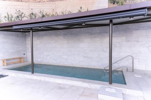 a swimming pool under an awning on a patio at LEONIDIONHOUSES - The Lykoskufi Villas in Tiros