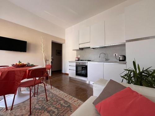 a living room with a table and a kitchen with white cabinets at Da' mi' nonni in Pistoia