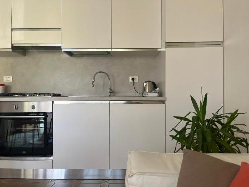 a kitchen with white cabinets and a sink at Da' mi' nonni in Pistoia