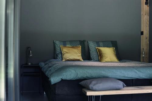 a bed with yellow and blue pillows on it at Luxury of Nature - boutique in Helvoirt