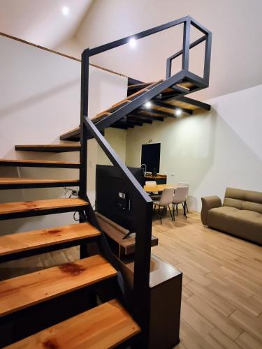 a living room with a staircase and a desk at Cabaña Rincón Verde in San Juan Chamelco