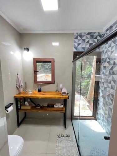 a bathroom with a sink and a glass shower at Cabanas Cantareira - Araucária in Mairiporã