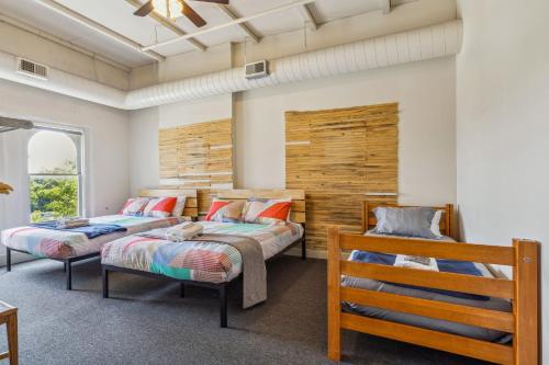 a bedroom with two beds and a bench at The Victor 3 - Cleveland's Urban Lodge in Cleveland