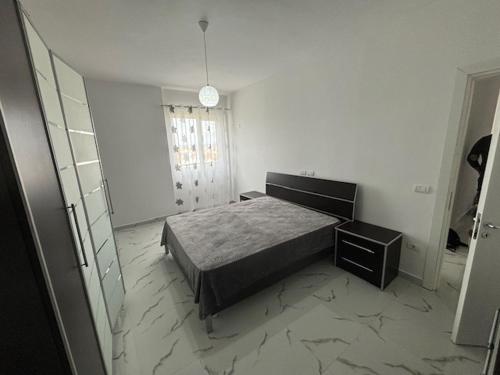 una camera da letto con un letto, una cassettiera e uno specchio di Armonia a Durrës