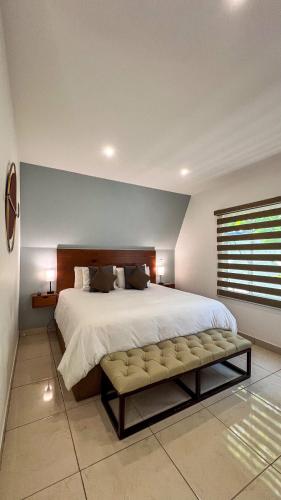 a large bedroom with a large bed and a bench at VILLAS EL ENCANTO in Jalpan