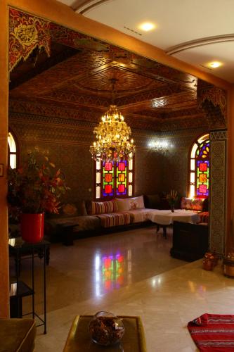 a large living room with a chandelier and stained glass windows at Riad Noumidya in Fès
