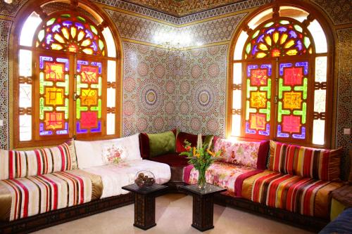 a living room with a couch and stained glass windows at Riad Noumidya in Fès