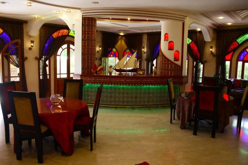 a restaurant with tables and chairs and stained glass windows at Riad Noumidya in Fès