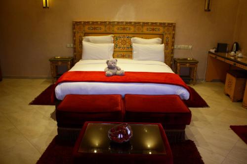 a teddy bear sitting on a bed in a hotel room at Riad Noumidya in Fès