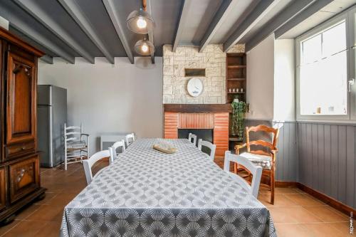 une salle à manger avec une table et des chaises et une cheminée dans l'établissement L'ancienne boulangerie de Villeneuve- sur- Vère, à Villeneuve-sur-Vère