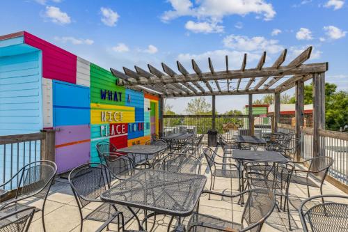 a patio with tables and chairs and a colorful wall at The Victor 3 - Cleveland's Urban Lodge in Cleveland