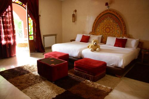 a teddy bear sitting on a bed in a bedroom at Riad Noumidya in Fès