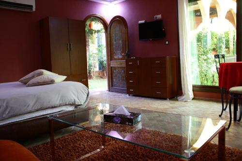 a bedroom with a bed and a glass table at Riad Noumidya in Fès