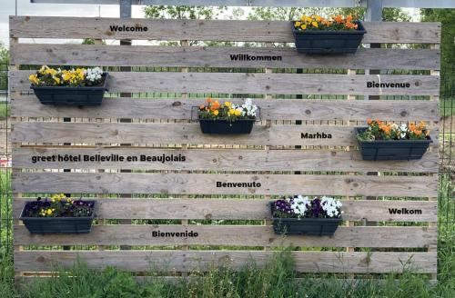 a wooden fence with flowers in pots on it at greet Hotel Belleville en Beaujolais A6 in Belleville-sur-Saône